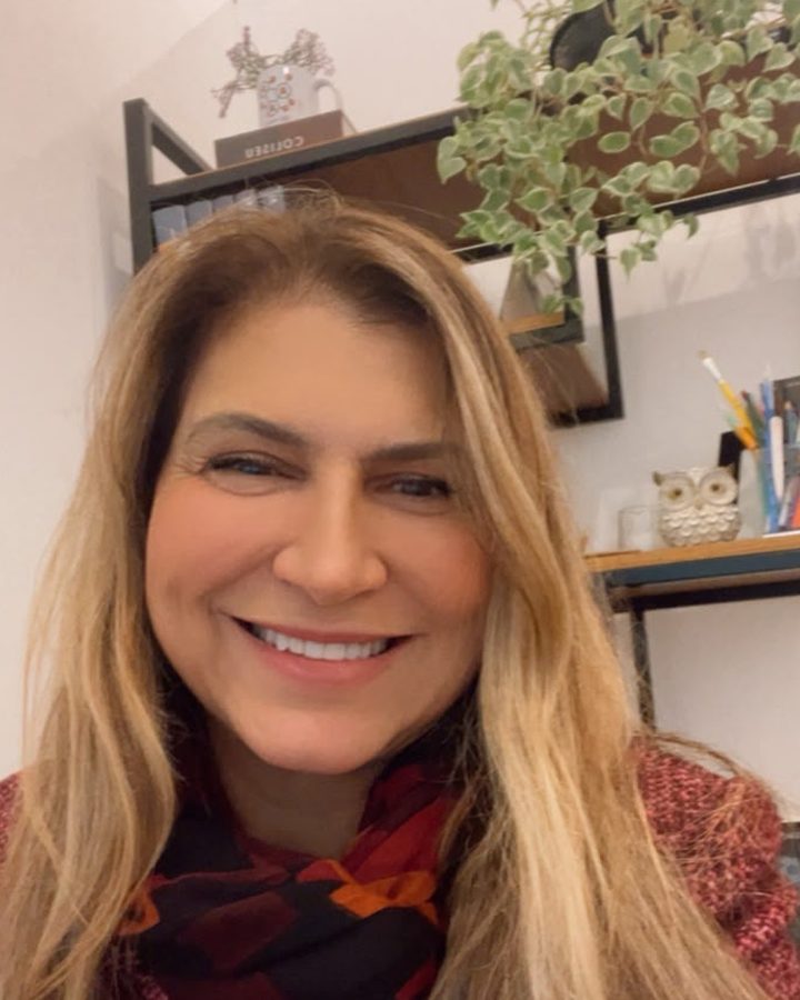 Christina Faria, psicóloga e neuropsicóloga, sorrindo em seu consultório